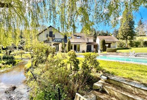 une maison avec une piscine dans une cour dans l'établissement Le moulin de la Vernoelle, à Prémilhat