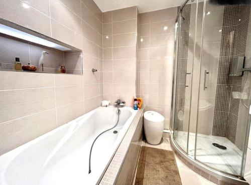 uma casa de banho com uma banheira, um chuveiro e um WC. em Le moulin de la Vernoelle em Prémilhat