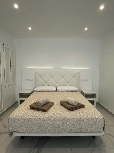 マスパロマスにあるLuxury bungalow Maspalomas Gran Canariaのベッドルーム1室(ベッド1台、タオル2枚付)