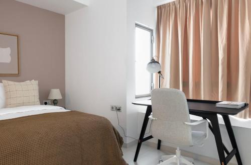 1 dormitorio con escritorio, 1 cama y 1 silla en Modern Heights 2BR apartment in Singapore!, en Singapur