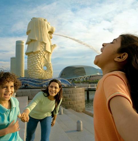 dos mujeres frente a una estatua de un león en Modern Heights 2BR apartment in Singapore!, en Singapur