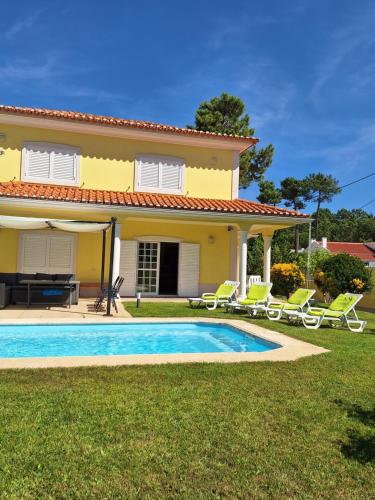 a villa with a swimming pool in front of a house at B House Verdizela in Corroios