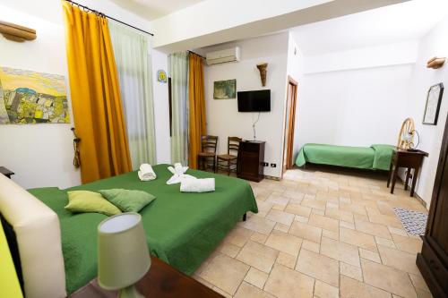 a bedroom with a green bed and a living room at B&B Villa Anna in Marinella di Selinunte