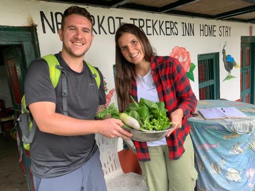 a man and a woman holding a bowl of vegetables at Nagarkot Trekkers Inn in Nagarkot