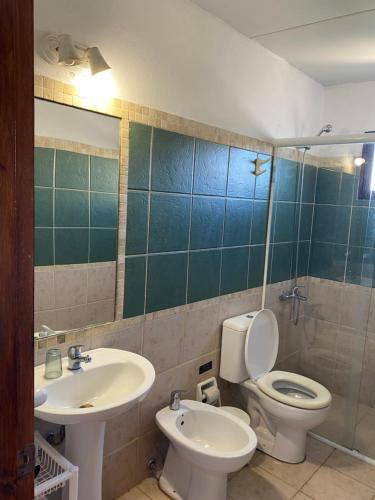 y baño con lavabo, aseo y espejo. en Medanos del Portal, en Piriápolis