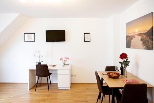 a dining room with a table and a television on the wall at Premium 80 m2 Rooftop Apartment - 5 min to Center in Vienna