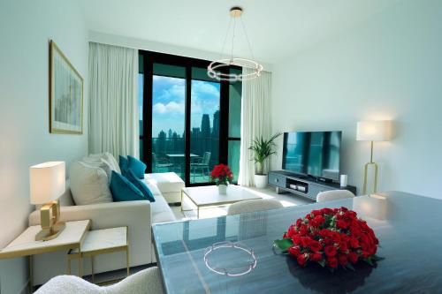 a living room with a large white couch and a living room with flowers on top at Elegant Apartment with Direct access to Dubai Mall in Dubai
