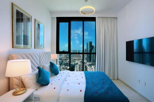 a bedroom with a bed and a large window at Elegant Apartment with Direct access to Dubai Mall in Dubai