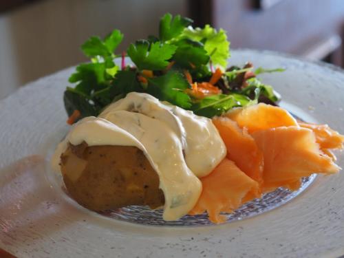 a plate of food with salmon and a salad at Hotel Lüttje Burg in Lütjenburg