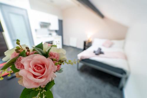 a vase with a pink rose in a living room at Remarkable 1-Bed Studio in Birmingham in Birmingham