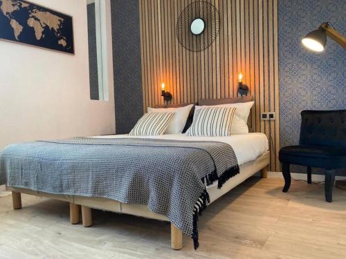 a bedroom with a large bed and a blue chair at Appart'Hotel - Gare TGV - Courtine - Confluence - 407 bis in Avignon