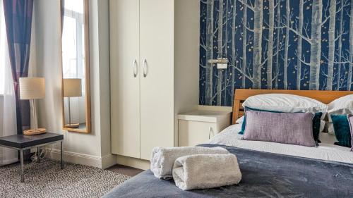a bedroom with a bed and a blue and white wall at New Steine Apartment - Sea View - by Brighton Holiday Lets in Brighton & Hove