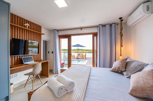 a bedroom with a bed and a desk with a laptop at Bahia Soul - Casa Cali - Barra Grande - Península de Maraú in Barra Grande