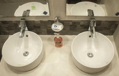 La salle de bains est pourvue de 2 lavabos blancs et d'un miroir. dans l'établissement Mangrove Inn, 