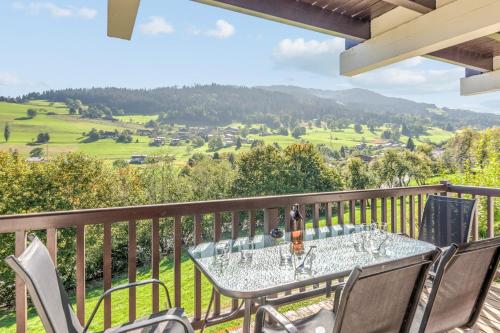 une table sur un balcon avec vue sur les montagnes dans l'établissement Appartement Chablis - Welkeys, à Combloux