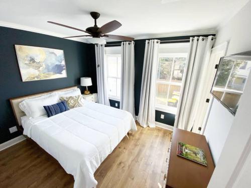 a bedroom with a white bed and a ceiling fan at Magnolia Estate - 3 Separate Units, Courtyard in Savannah