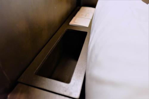 a small room with a bed and a window at Sleep Here Hostel, Melaka in Melaka
