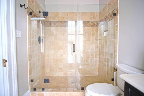 a bathroom with a shower with a toilet at Chatham House - Historic 3 BR on Chatham Square in Savannah