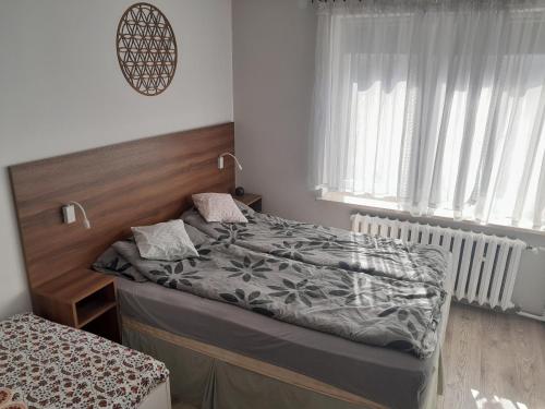 a bedroom with a bed with a wooden headboard at Miodowa in Zwierzyniec