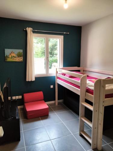 - une chambre avec deux lits superposés et une chaise rouge dans l'établissement Maison du rieu 8 personnes, à Saint-Geniès
