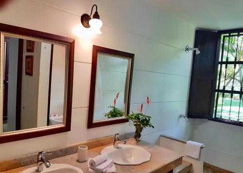a bathroom with two sinks and two mirrors at Hacienda la Romelia 