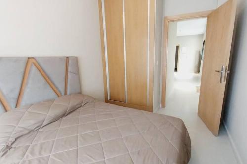 een slaapkamer met een bed en een open deur bij Appartement cosy proche Aéroport in Deroua