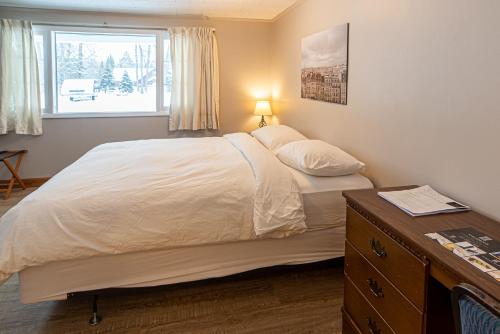 a bedroom with a bed with a dresser and a window at Star Gate Motel in Indian River