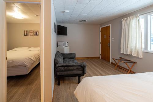 a bedroom with a bed and a chair in a room at Star Gate Motel in Indian River