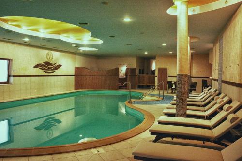 una piscina en una habitación de hotel con sillas y una piscina en Hotel Victoria en Martin