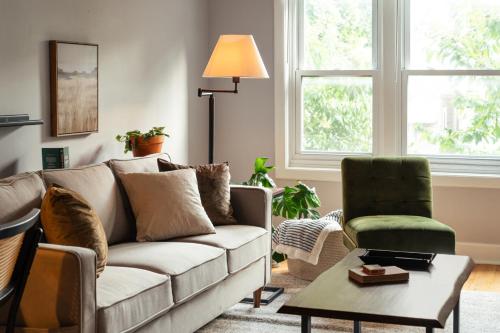 uma sala de estar com um sofá e uma cadeira em Flexhome Logan Square 1BR Apt B1 - READ INFO em Chicago