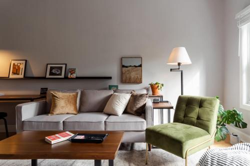 uma sala de estar com um sofá, uma mesa e uma cadeira em Flexhome Logan Square 1BR Apt B1 - READ INFO em Chicago