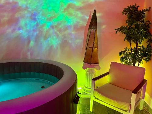 een kamer met een bad, een stoel en een regenboog bij Espace détente jacuzzi sauna in Gagny