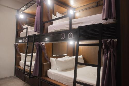 a room with four bunk beds with lights on them at Sleep Here Hostel, Melaka in Malacca
