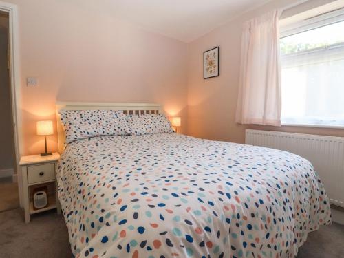 a bedroom with a bed with a polka dot bedspread at 46 By The Creek in Faversham