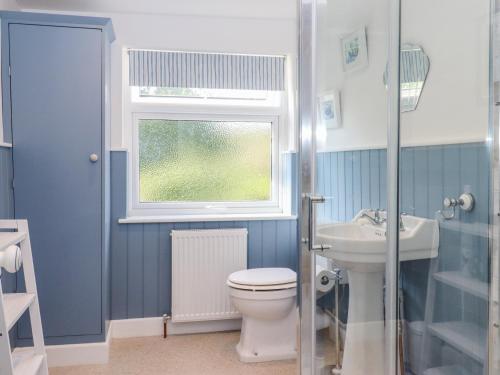 baño con aseo y lavabo y ventana en 46 By The Creek, en Faversham