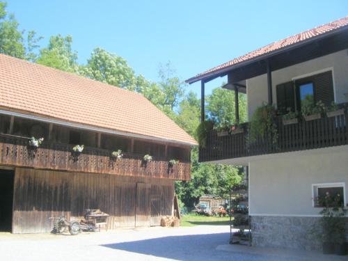 um edifício com uma varanda com flores em Guest House Kmetija em Dane