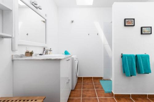 eine weiße Küche mit einem Waschbecken und einem Spiegel in der Unterkunft Casa Marisa with Heated Pool & Garden in Tindaya