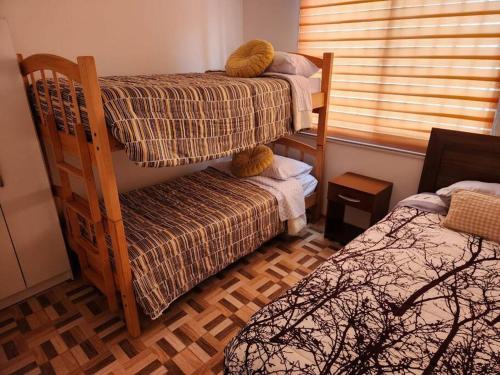 a bedroom with two bunk beds and a window at Casa 10 personas cerca de Bahia Inglesa in Caldera