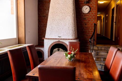 a dining room with a table and a fireplace at Hotel Lüttje Burg in Lütjenburg