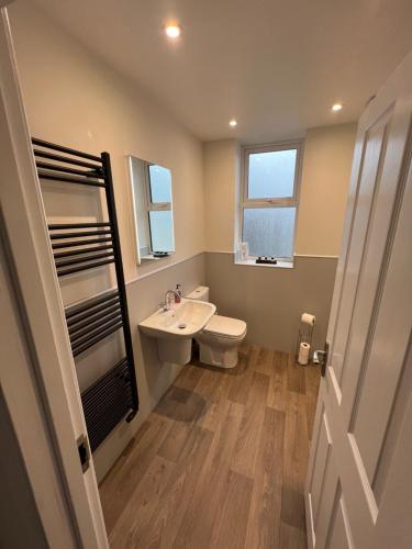 a bathroom with a sink and a toilet and a window at Dolly Waggon Guest House in Keswick