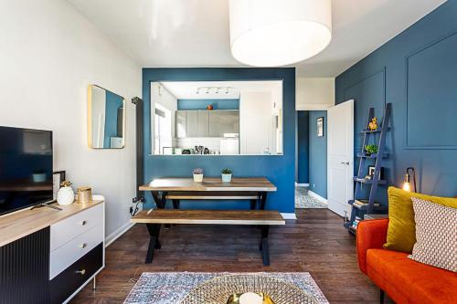 a living room with a table and a blue wall at Beautiful Aldgate Apartment in London