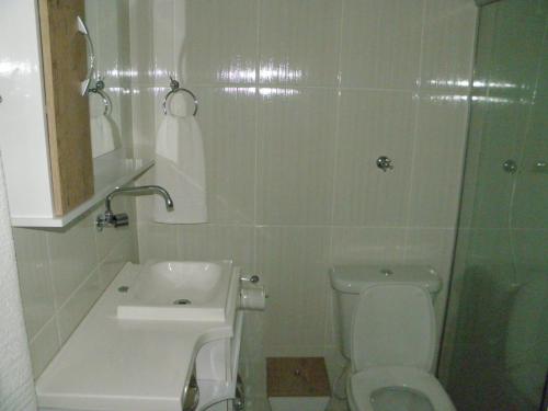 a bathroom with a toilet and a sink and a shower at Pousada Costa e Mar in Tavares