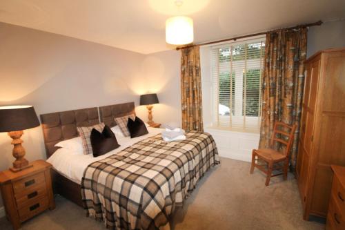 a bedroom with a bed and a window at Old Bakers Cottage ground floor apartment centrally located in Grasmere with patio area in Grasmere