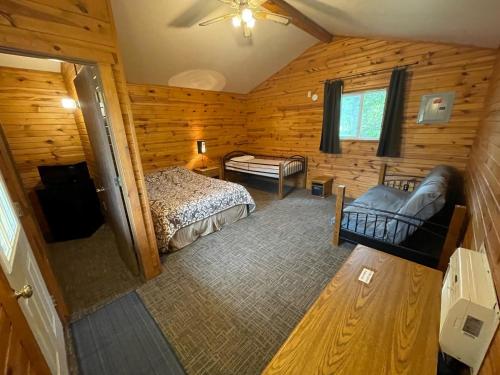 Elk Creek Resort في Piedmont: غرفة نوم في كابينة خشب بها سرير وأريكة