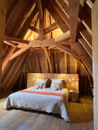 une chambre avec un lit dans un grenier dans l'établissement Le Lapin sur le Toit - Magnifique grange du XVIIIème, à Rouffignac-Saint-Cernin-de-Reilhac