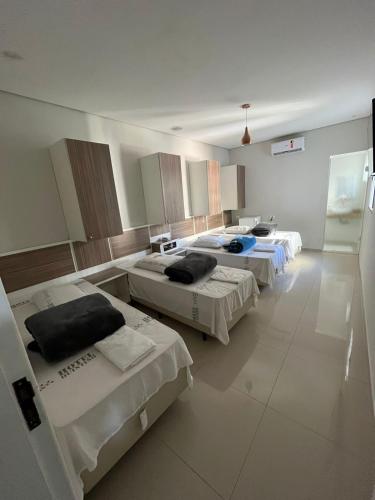 a hospital room with three beds in it at Hotel Quintino - Metrô Sé -localizado no coração de São Paulo Próximo 10 minutos do Brás 5 minutos da 25 de Março e com estacionamento no local grátis in Sao Paulo