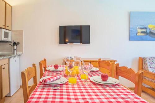 a table with a red and white checkered table cloth at Aptos. Comte D´Empuries in Empuriabrava