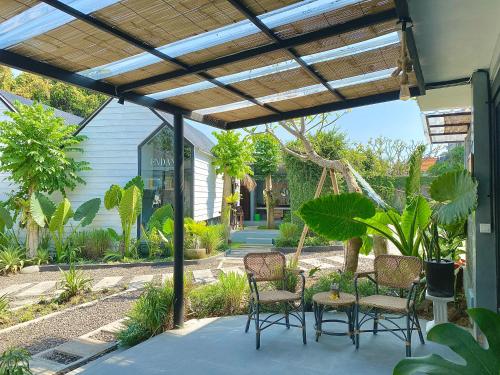 a pergola with chairs and a table on a patio at The Jungle Hostel Canggu in Canggu