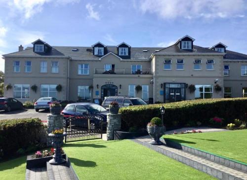 una casa grande con coches estacionados frente a ella en Bernie’s Place, en Ballyliffin