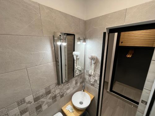 a bathroom with a sink and a mirror at Pensión Cassandra in Buzanada